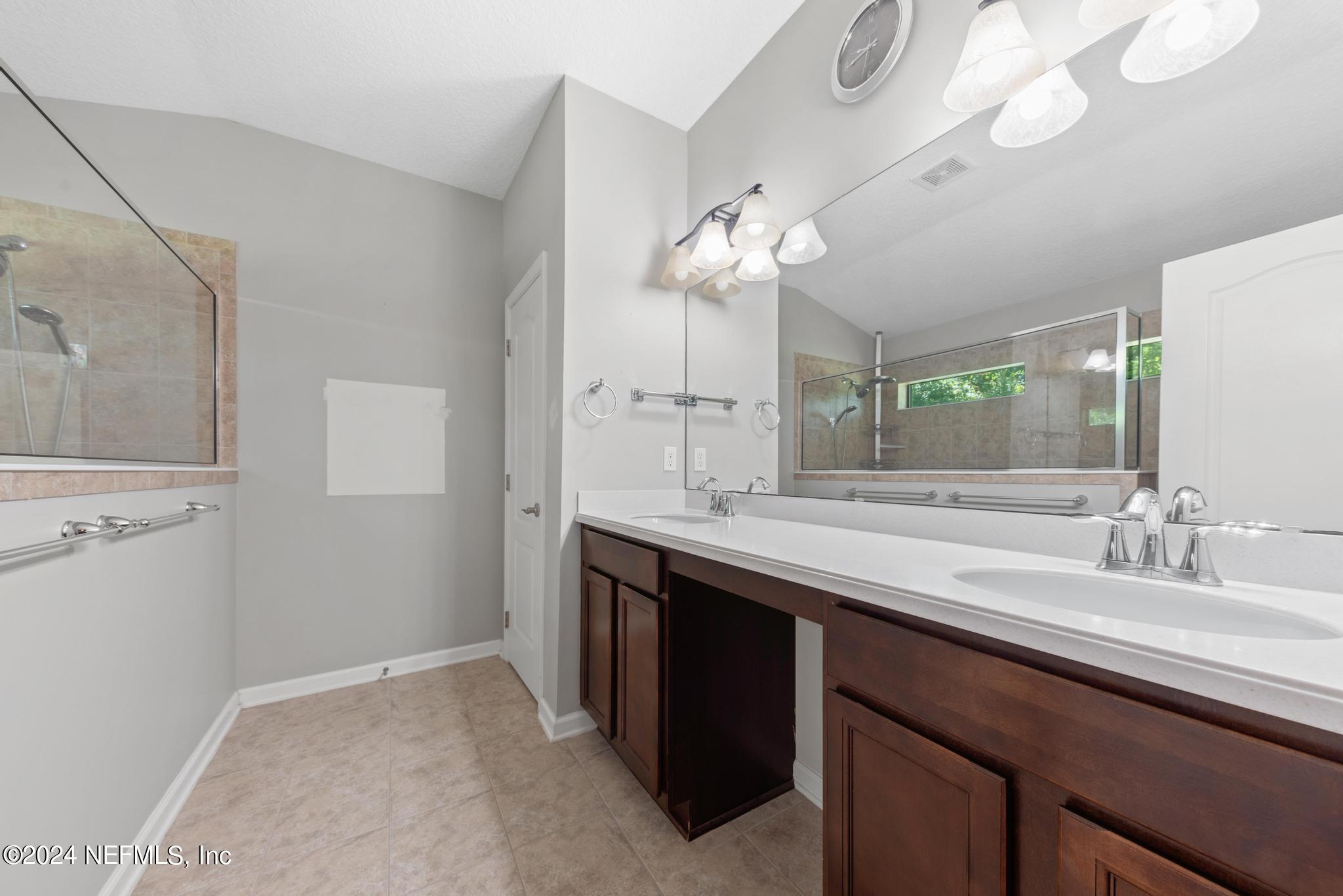 86192 Fortune Drive Yulee, FL 32097 - Photo 15 of 26 a spacious bathroom with a granite countertop sink a toilet and a mirror