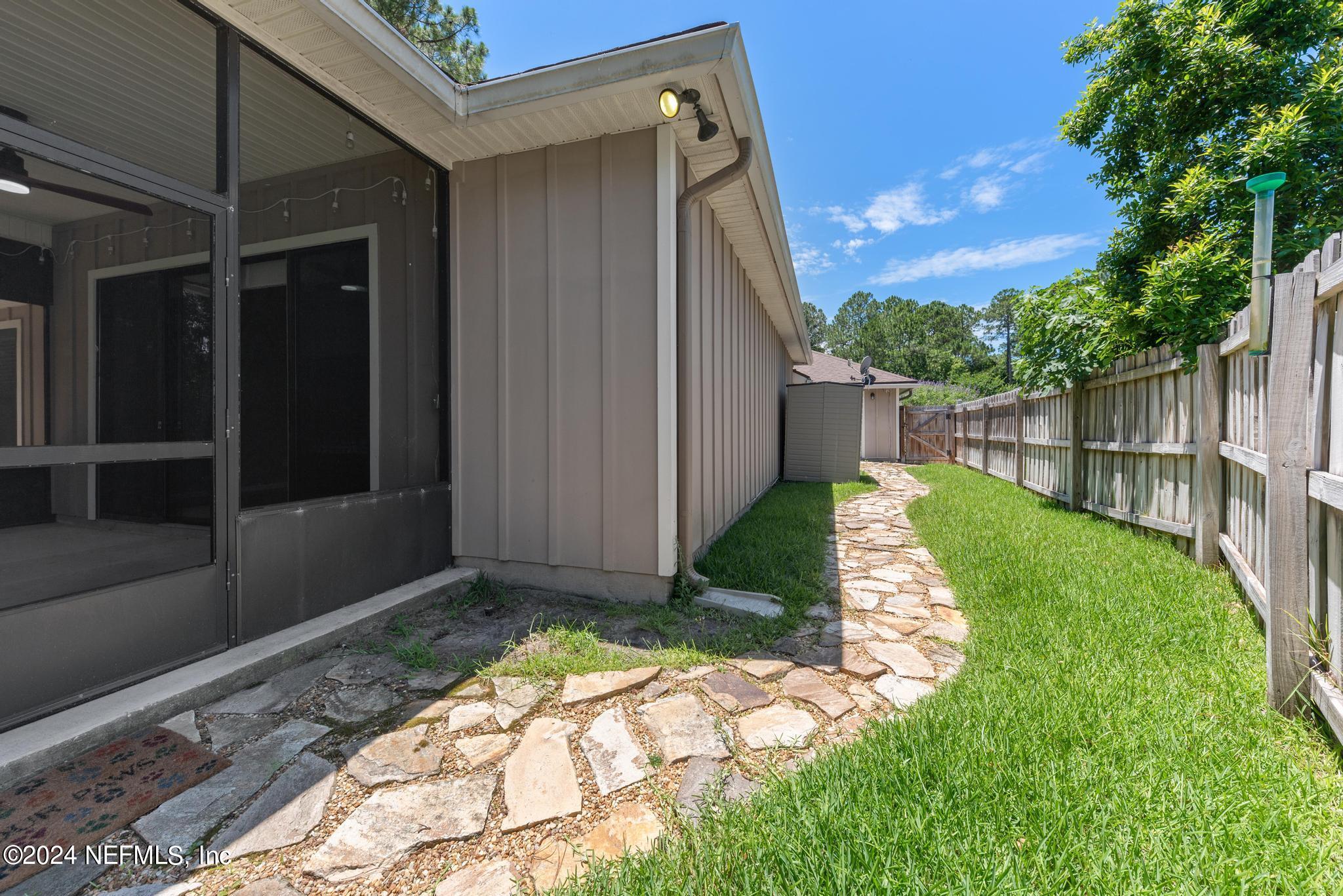 86192 Fortune Drive Yulee, FL 32097 - Photo 23 of 26 a view of backyard with potted plants and wooden fence