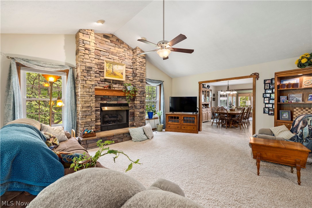 8737 River Corners Road Homerville, OH 44235 - Photo 6 of 46 Great room with high vaulted ceiling, ceiling fan with notable chandelier, carpet floors, and a fireplace