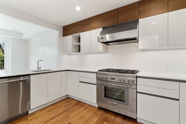 a kitchen with granite countertop a stove and a wooden floor