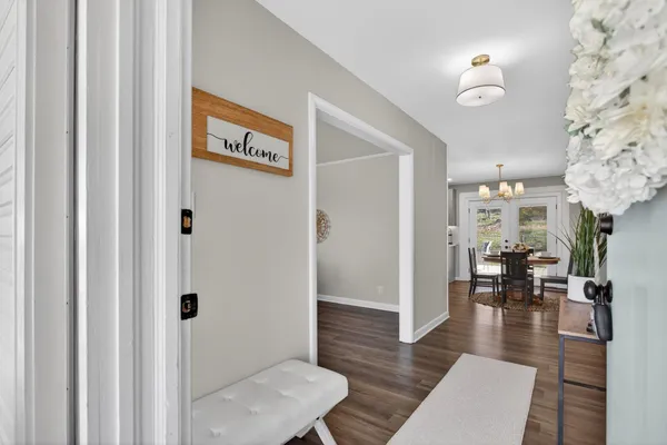 a living room with furniture a large window and a wooden floor