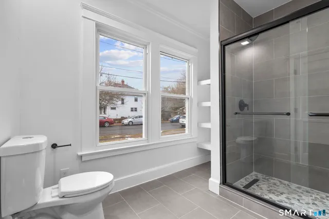 a bathroom with a toilet and a shower