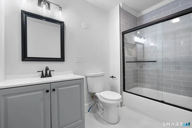 a bathroom with a granite countertop sink toilet and shower
