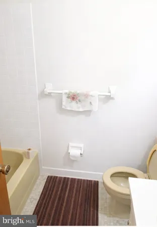 a bathroom with a granite countertop sink mirror vanity and toilet
