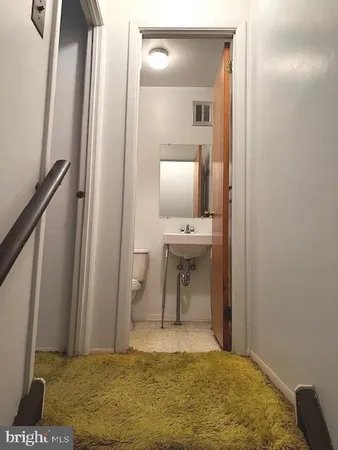 a bathroom with a toilet a sink and mirror