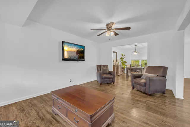 a kitchen with stainless steel appliances wooden floor dining table and chairs