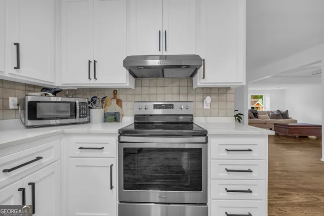 a kitchen with stainless steel appliances granite countertop a sink and a stove