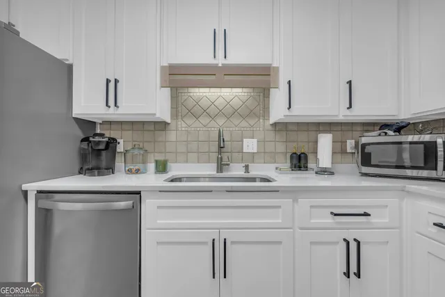 a view of a dining room and livingroom with furniture wooden floor a chandelier