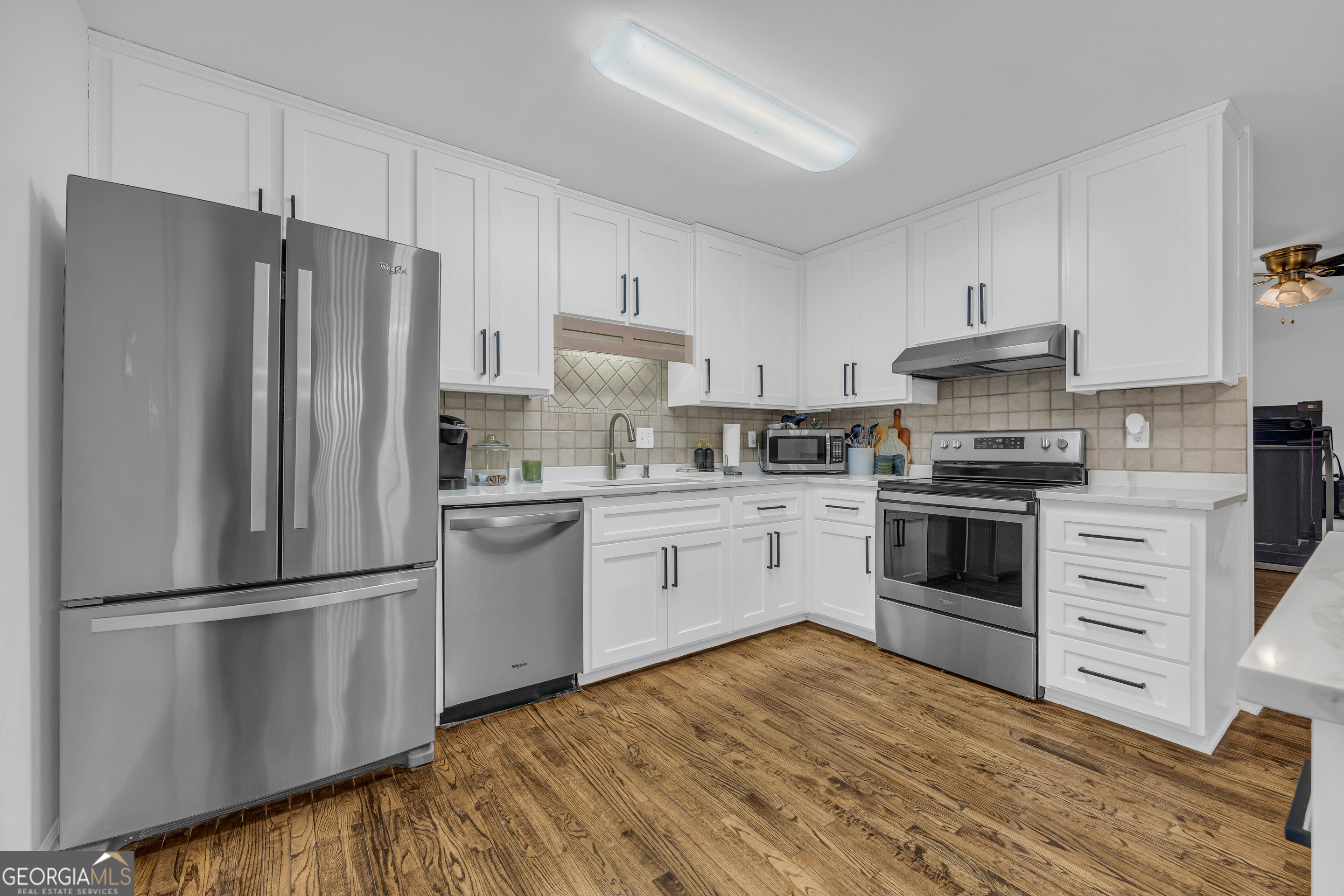 619 Watson Street Toccoa, GA 30577 - Photo 3 of 28 a kitchen with a refrigerator stove and white cabinets