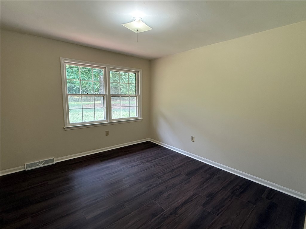 1507 East Calhoun Street Anderson, SC 29621 - Photo 11 of 18 Rich hardwood-style flooring extends across this spacious room, complemented by views of mature trees from the windows.