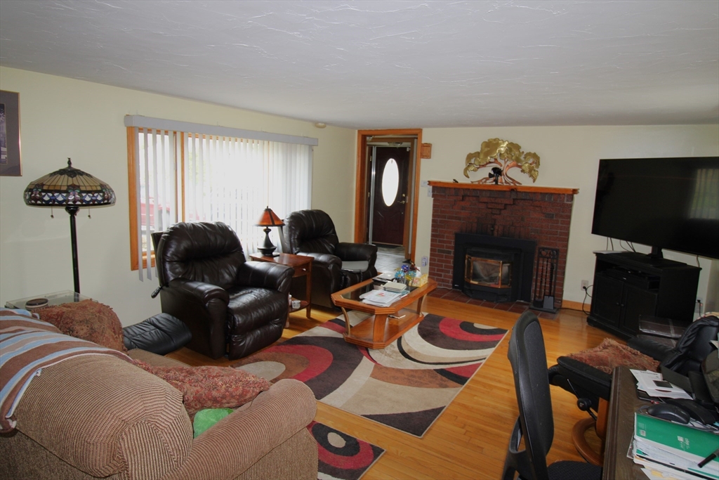 34 Dale Road Holbrook, MA 02343 - Photo 8 of 35 a living room with furniture a flat screen tv and a fireplace
