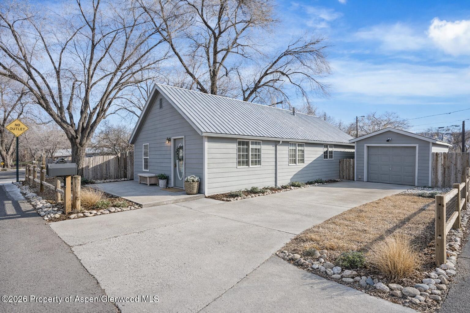 109 East 12th Street Rifle, CO 81650 - Photo 2 of 31 a front view of a house with a yard and garage