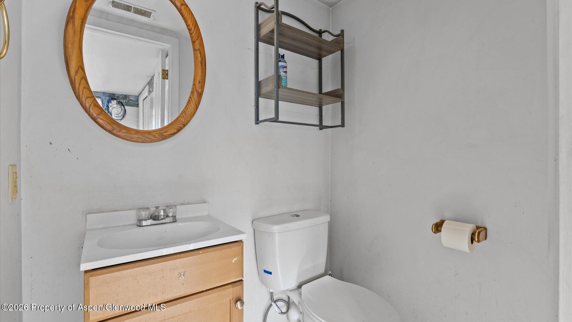 109 East 12th Street Rifle, CO 81650 - Photo 21 of 31 a bathroom with a toilet a sink and a mirror