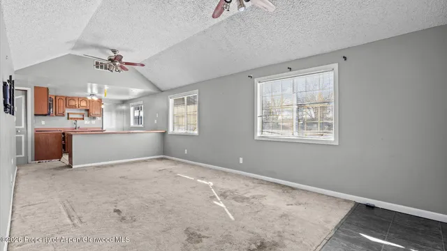 a kitchen with stainless steel appliances granite countertop a stove top oven a sink dishwasher and a refrigerator with wooden cabinets