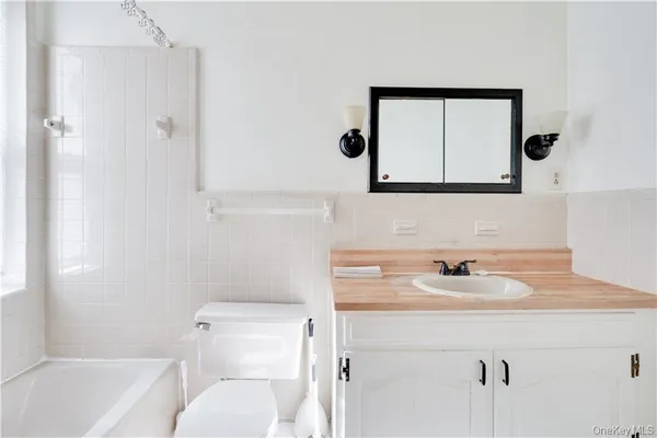 a bathroom with a sink toilet a mirror and vanity