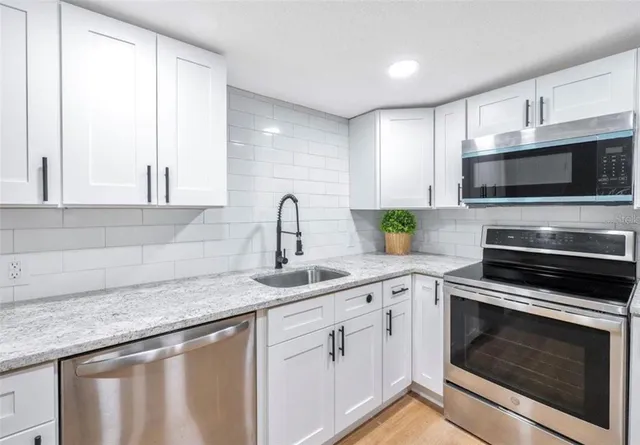 a kitchen with appliances a sink and cabinets