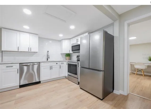 a kitchen with granite countertop stainless steel appliances and refrigerator