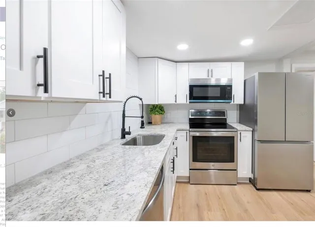 a kitchen with kitchen island a counter top space stainless steel appliances and cabinets