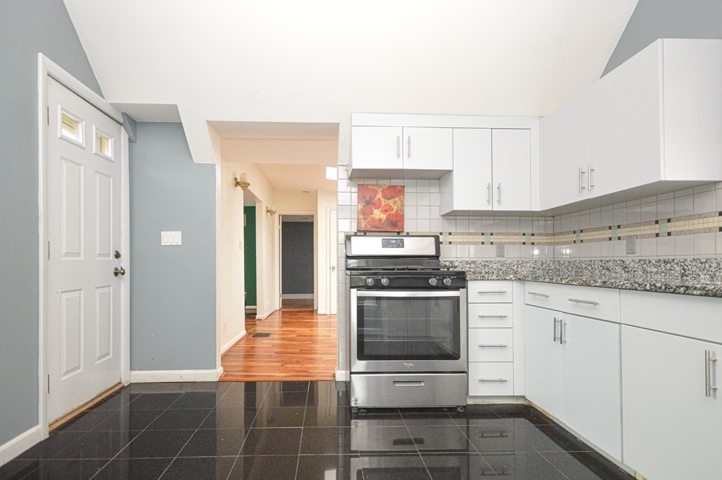 21 Carnes Street Lynn, MA 01905 - Photo 4 of 20 a kitchen with granite countertop a stove and white cabinets
