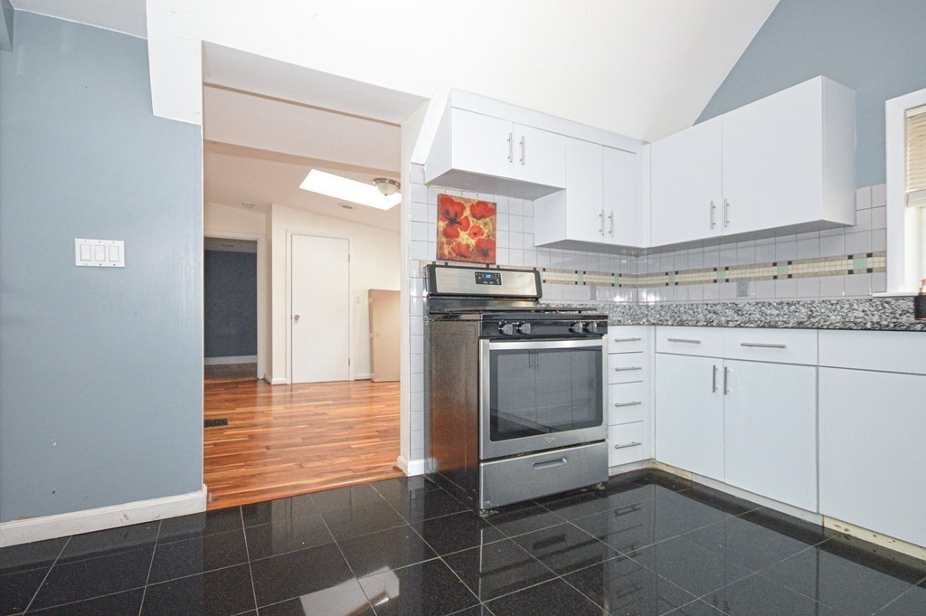 21 Carnes Street Lynn, MA 01905 - Photo 7 of 20 a kitchen with stainless steel appliances granite countertop a stove a sink and a refrigerator