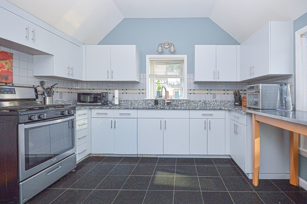21 Carnes Street Lynn, MA 01905 - Photo 9 of 20 a kitchen with a stove a sink and a refrigerator