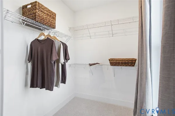 a view of walk in closet with clothes