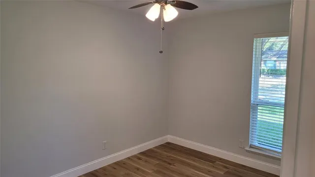 a view of a small space with wooden floor and a window