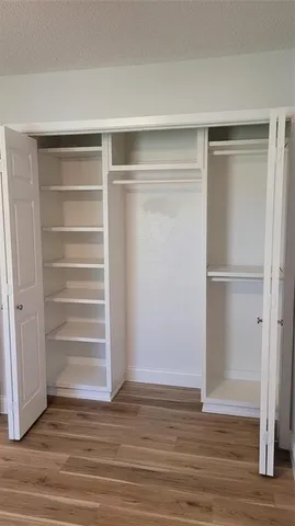 a view of walk in closet with empty racks