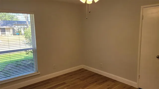a view of a small space with wooden floor and a window