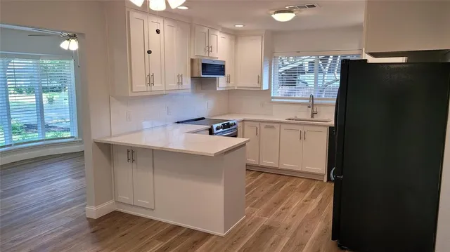 a kitchen with stainless steel appliances a refrigerator sink and microwave