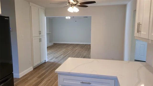 a view of a bedroom with wooden floor and a ceiling fan