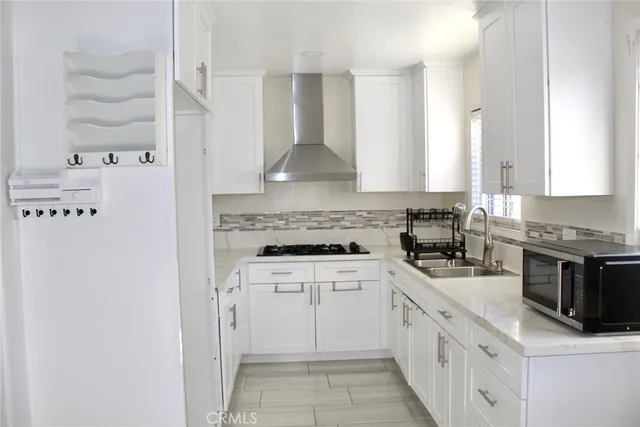 a white kitchen with a stove top oven