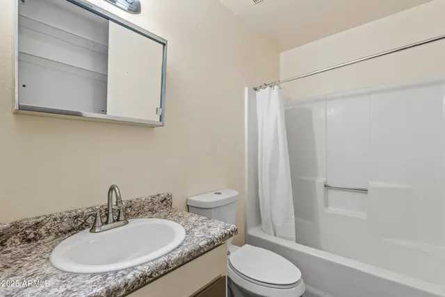 a bathroom with a granite countertop sink toilet a mirror and shower