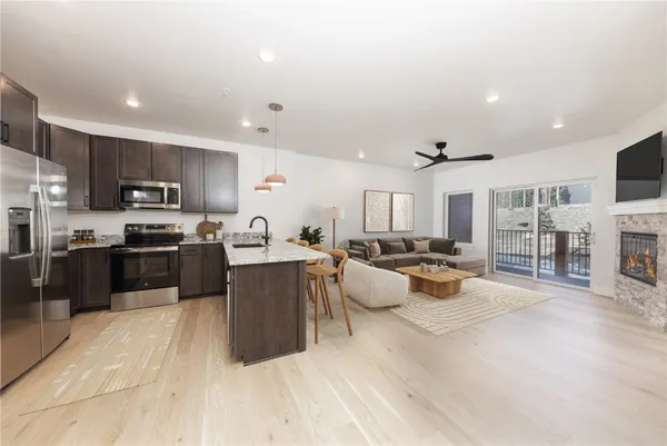 a large kitchen with kitchen island a large counter top space a sink a stove and a center island