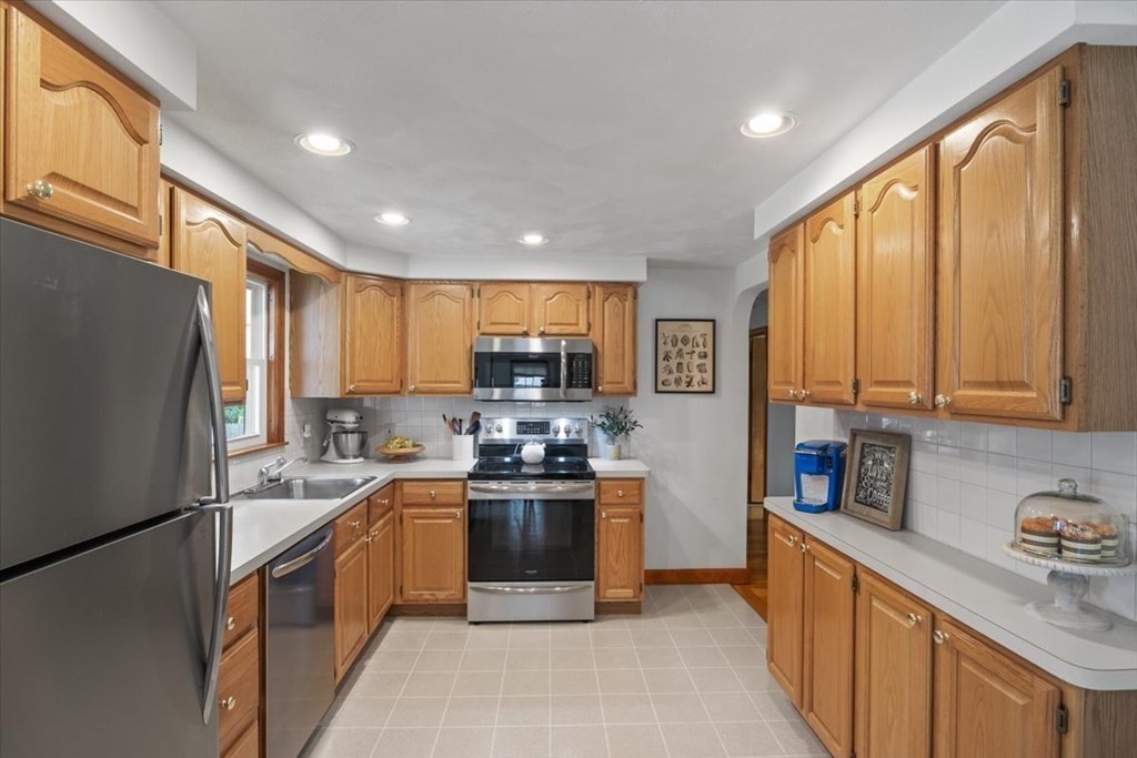23 Old Post Road East Walpole, MA 02032 - Photo 9 of 27 a kitchen with stainless steel appliances granite countertop a refrigerator a sink a stove top oven and cabinets