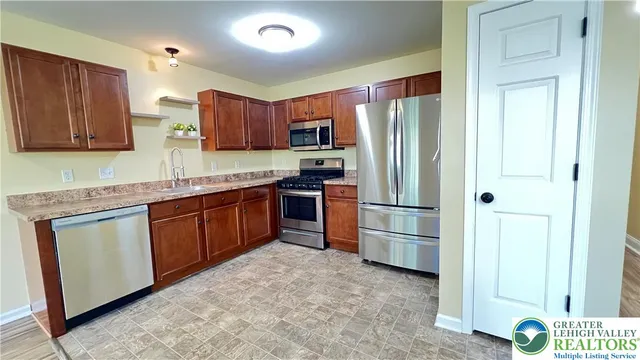 a kitchen with stainless steel appliances granite countertop a refrigerator stove and sink