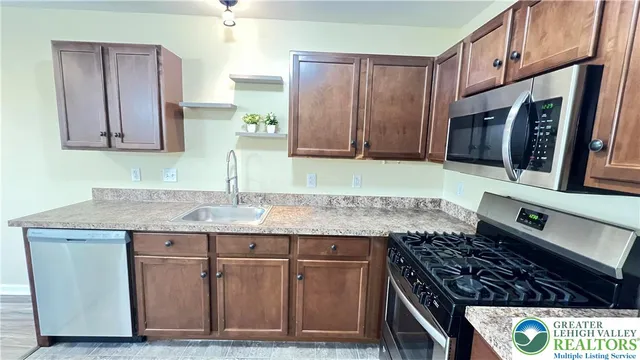 a kitchen with kitchen island granite countertop a stove sink and cabinets