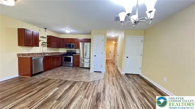 a view of kitchen with wooden floor and stainless steel appliances