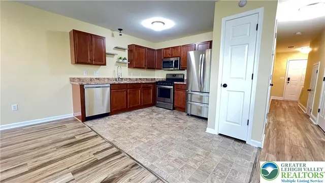 a kitchen with stainless steel appliances granite countertop a refrigerator stove and sink