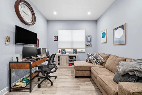 a living room with furniture a flat screen tv and a wall painting
