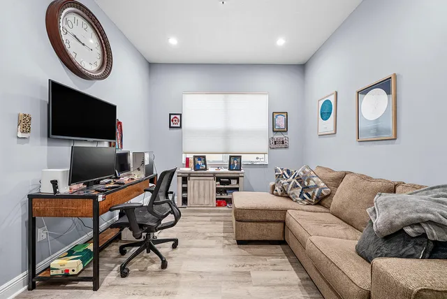 a living room with furniture a flat screen tv and a wall painting