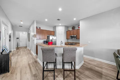 a kitchen with stainless steel appliances kitchen island granite countertop a kitchen island hardwood floor and a sink
