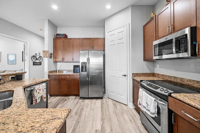 a kitchen with stainless steel appliances granite countertop a refrigerator stove and sink