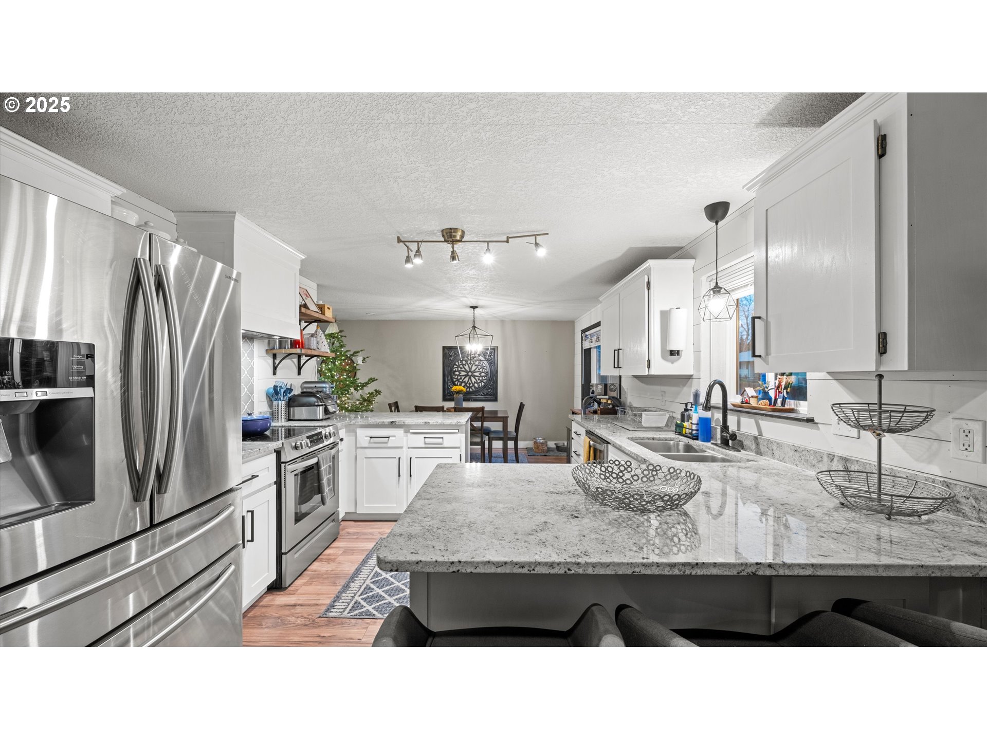 370 Southeast 9th Drive Hermiston, OR 97838 - Photo 15 of 31 a kitchen with stainless steel appliances kitchen island sink refrigerator and microwave