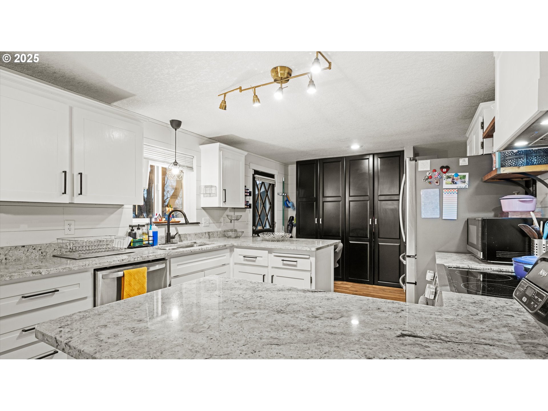 370 Southeast 9th Drive Hermiston, OR 97838 - Photo 10 of 31 a kitchen with stainless steel appliances kitchen island granite countertop a refrigerator and stove