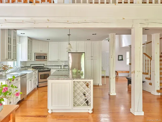 a kitchen with stainless steel appliances kitchen island granite countertop a refrigerator a stove top oven and a sink