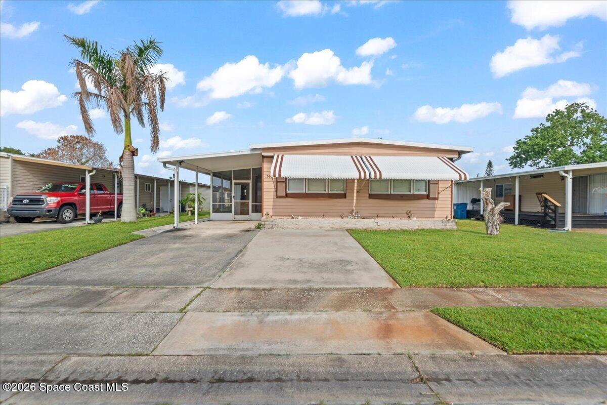 1740 Seagrape Street Northeast Palm Bay, FL 32905 - Photo 2 of 33 a front view of a house with a yard and potted plants