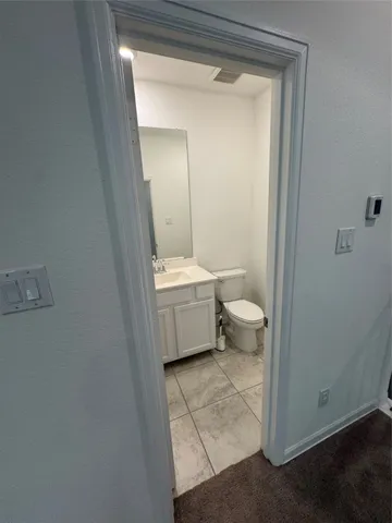 a bathroom with a toilet sink and a mirror