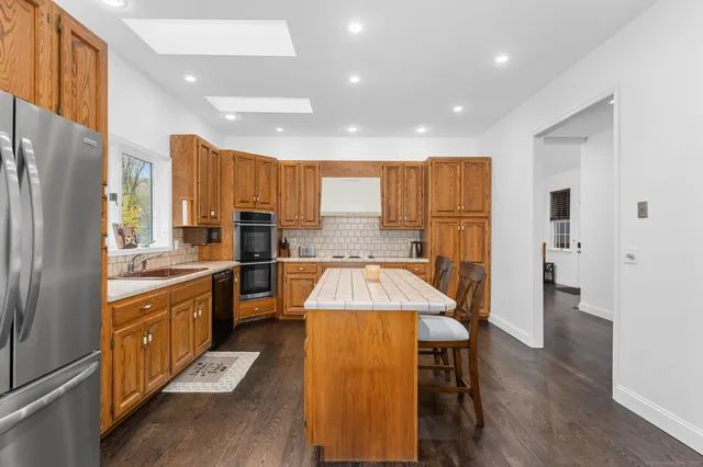 a large kitchen with a large window and stainless steel appliances