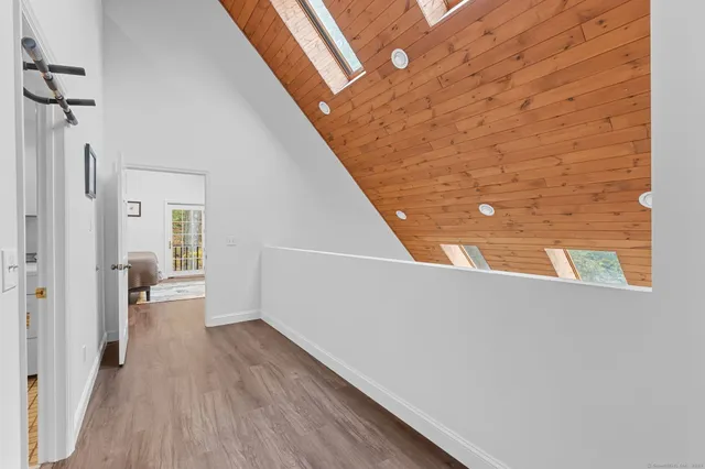 a view of a hallway with wooden floor and staircase